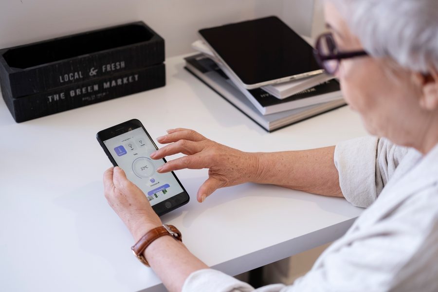 Senior and family member setting up medication app together on couch