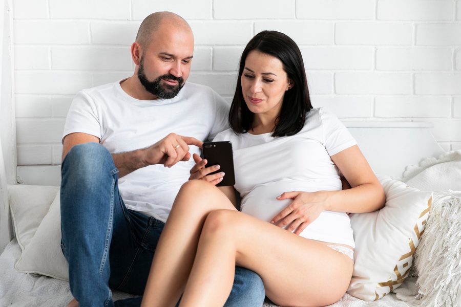 Smartphone screen showing AI fertility tracking dashboard with multiple biomarkers logged