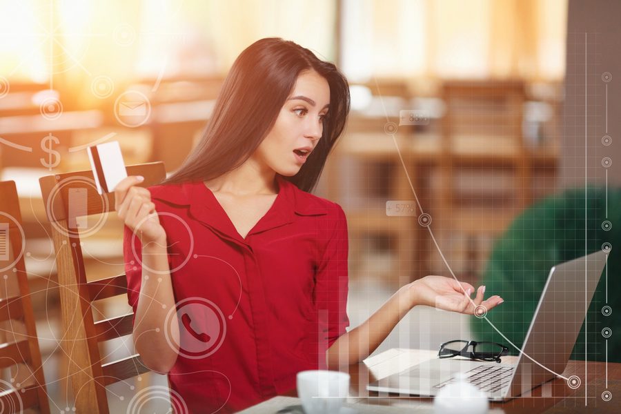 A person comparing AI lending platform offers on a laptop and bank loan paperwork on a desk.