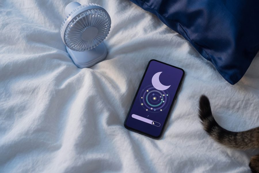 Smartphone on nightstand running AI sleep tracking app while person sleeps