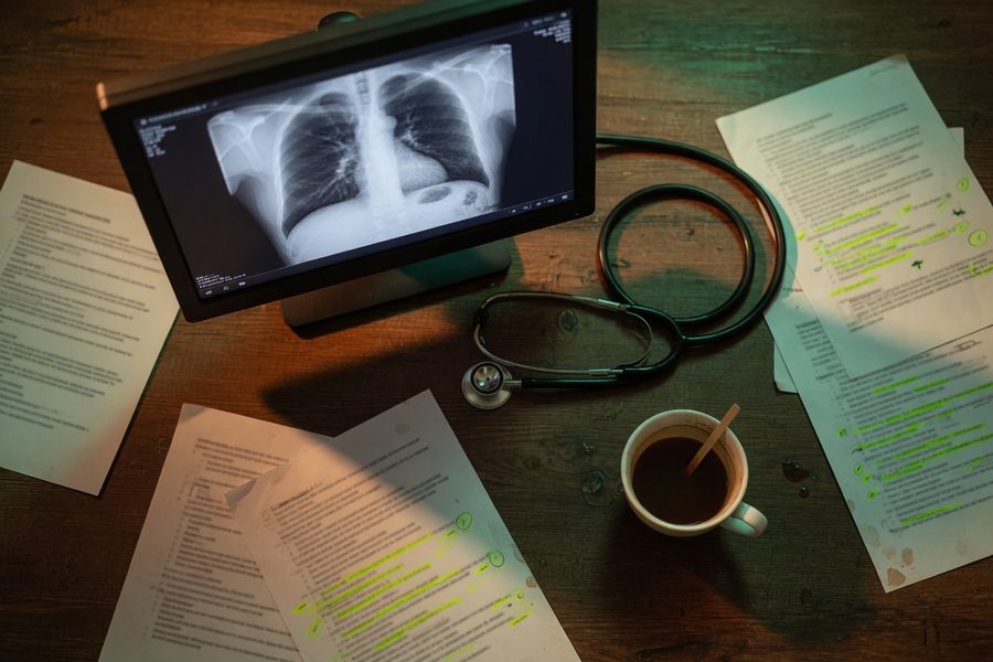 An ambient AI scribe device recording a consultation in a bright exam room
